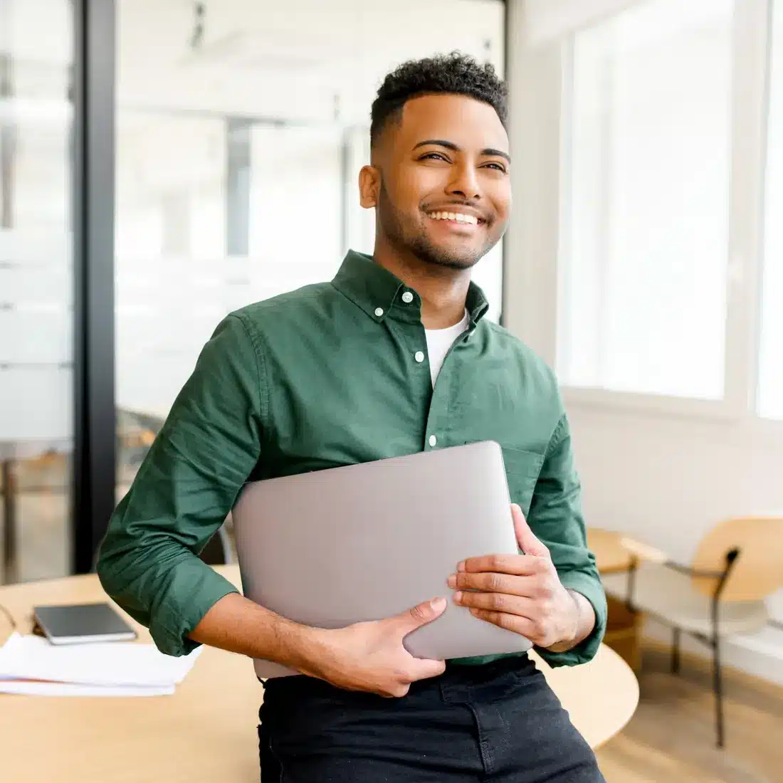 Account manager in a green shirt holding a laptop Account manager in a green shirt holding a laptop