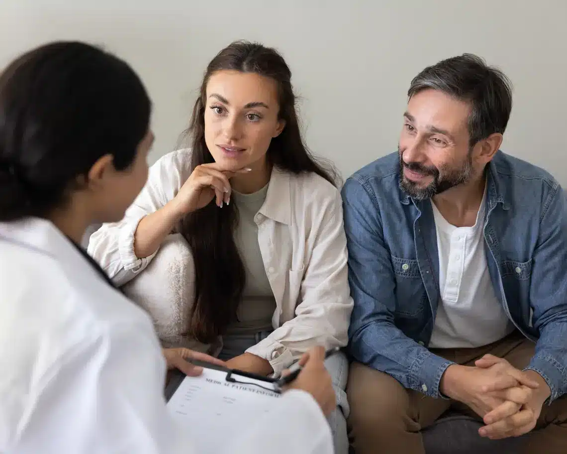 Fertility specialist consulting a couple in a bright clinic