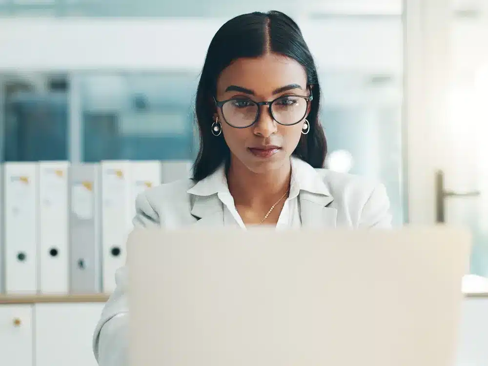 Authority Programs | CICOR Marketing Woman attorney focused on a laptop in a bright law office, an ideal client for an authority program