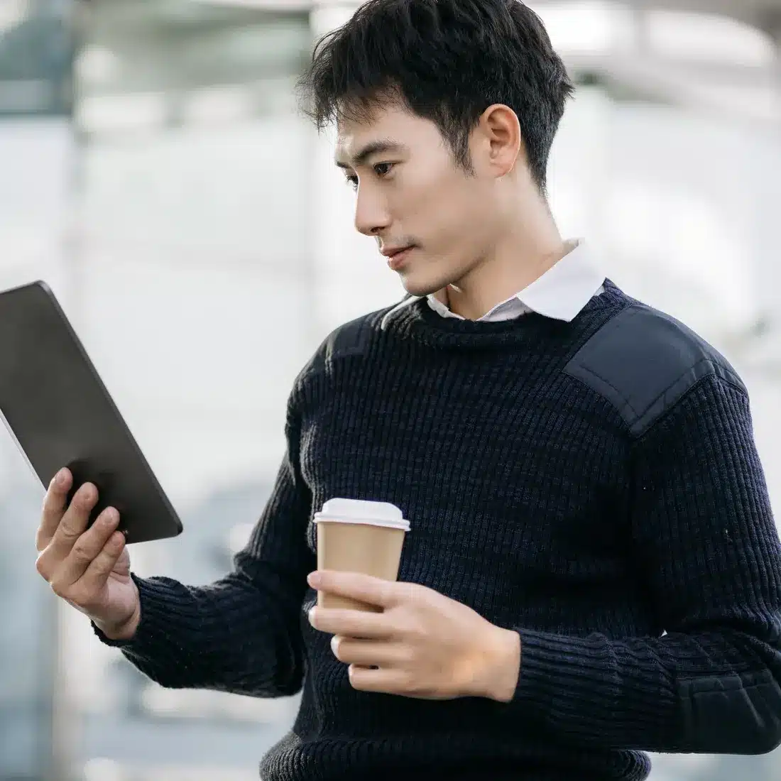 Marketer with a coffee checking campaign notes on a tablet Marketer with a coffee checking campaign notes on a tablet