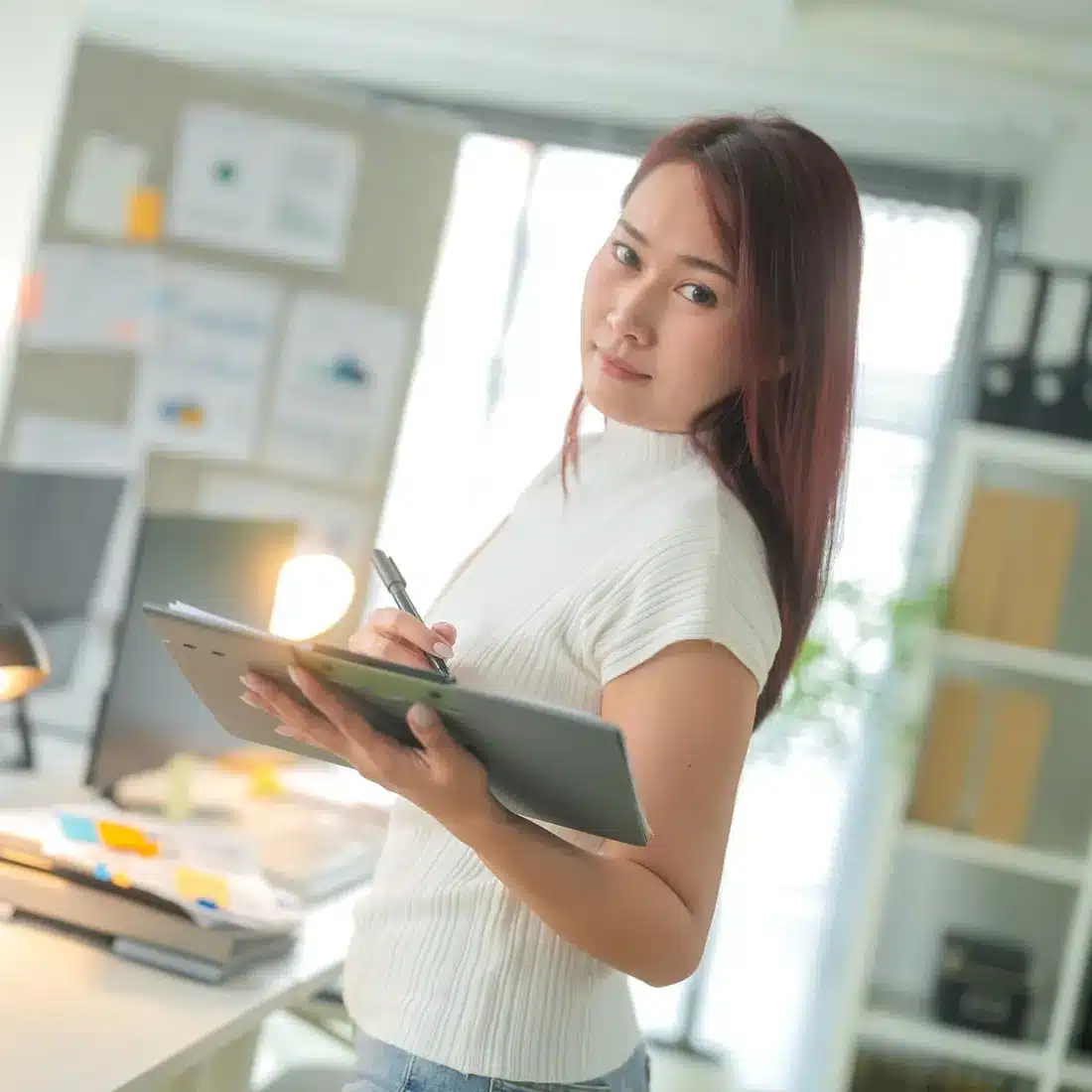 Marketing coordinator with a tablet at her workstation