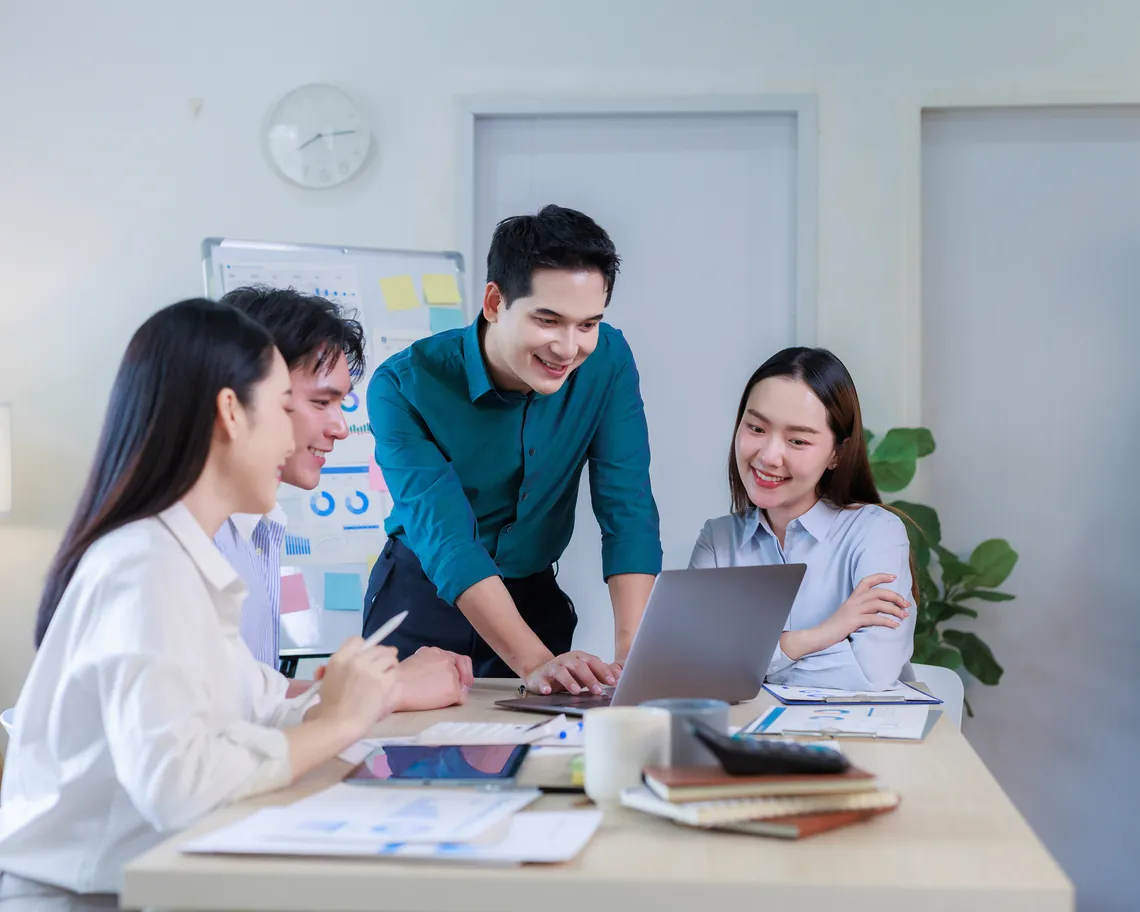 Marketing team discussing data at laptop