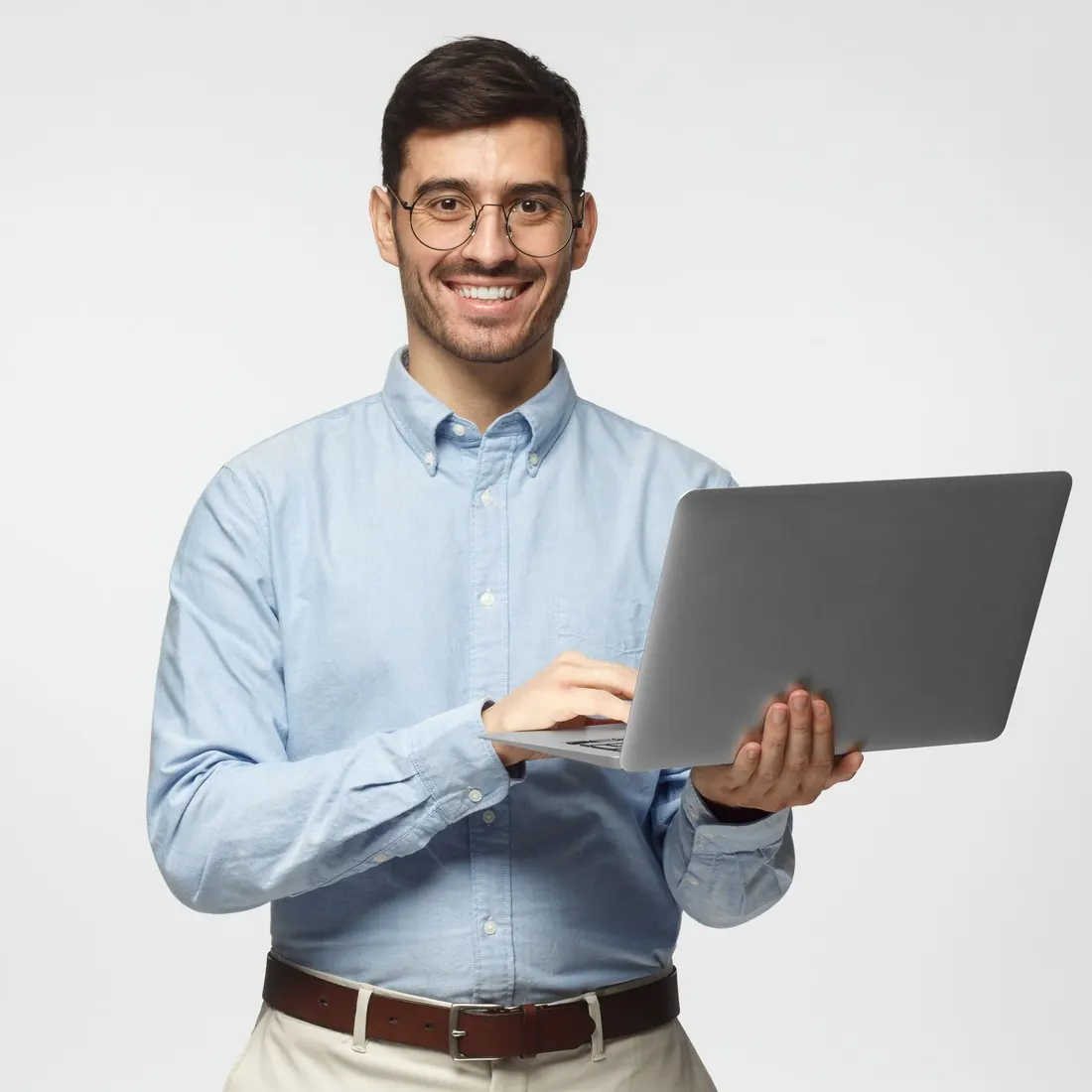 Smiling marketing specialist in glasses holding an open laptop