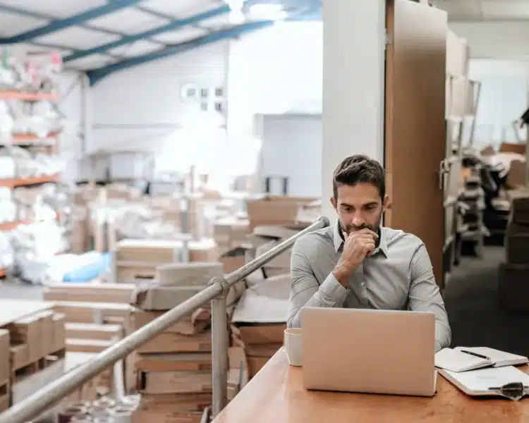 Warehouse manager working on a laptop